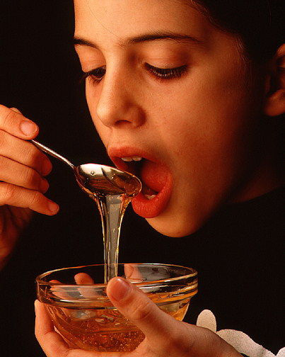 Young girl eating honey